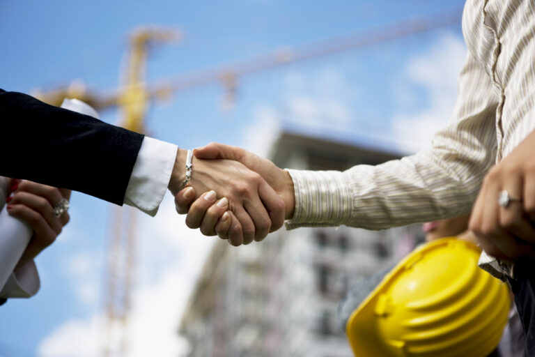 Two architects handshaking, selective focus